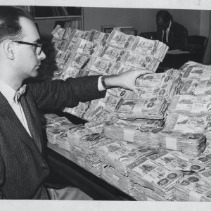 Man with pile of confederate money black and white