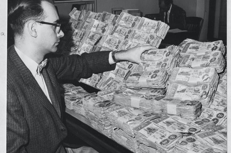 Man with pile of confederate money black and white