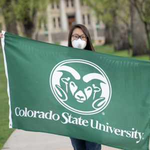 CSU student in mask holding flag