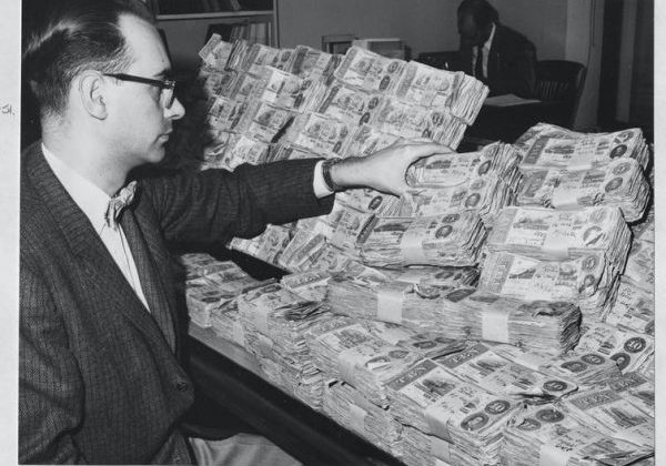 Man with pile of confederate money black and white