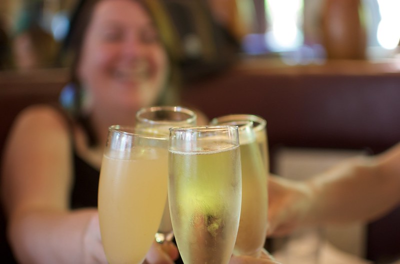 close up of four champagne glasses being toasted
