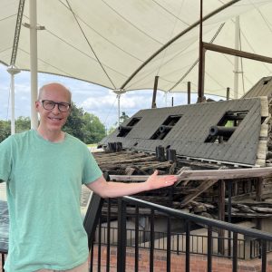 Professor in front of Civil War era ship