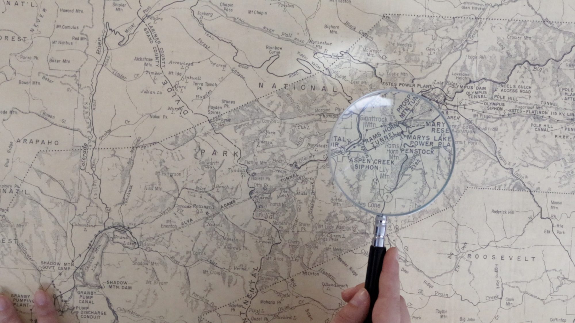 Magnifying glass held over a vintage Colorado map